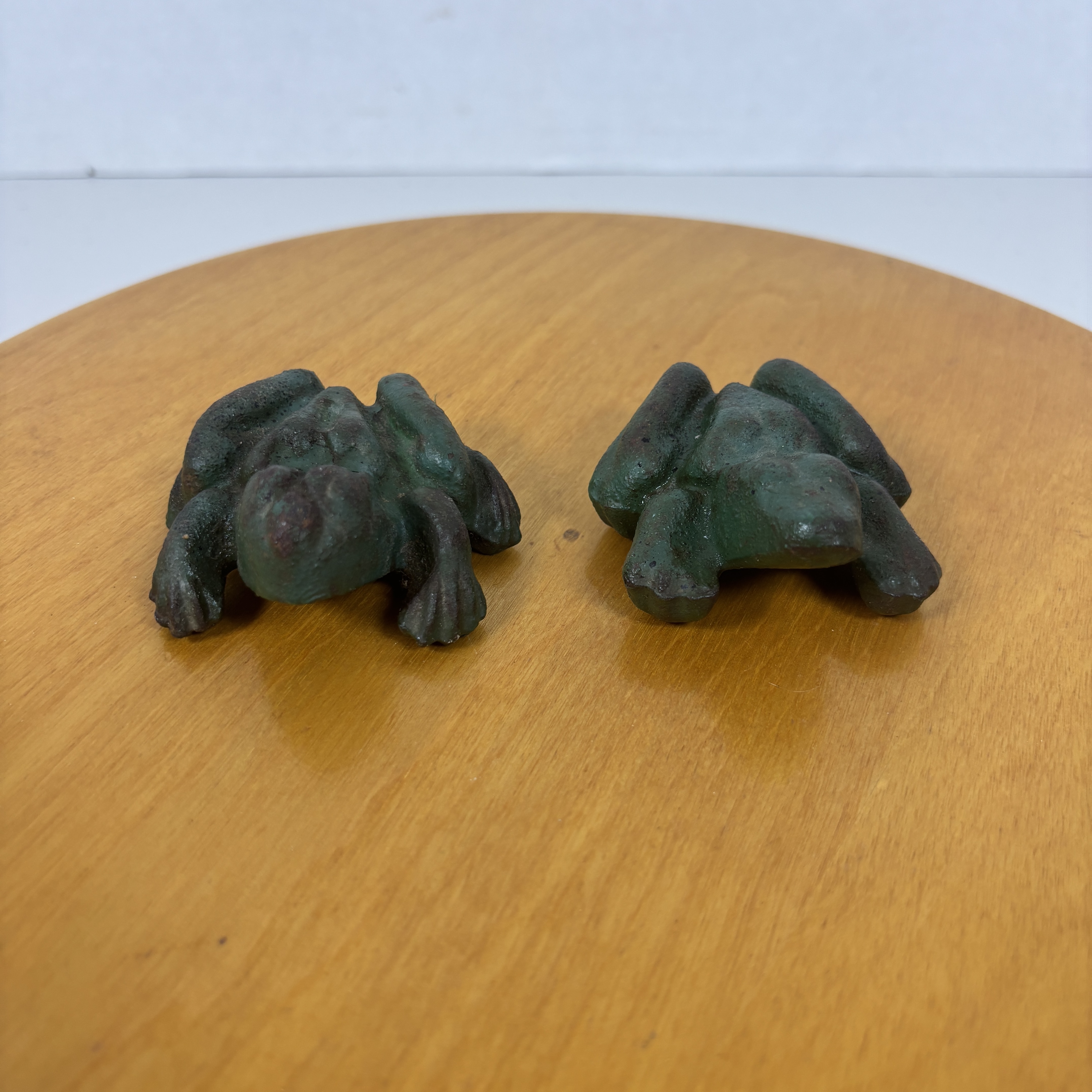 Pair of cast iron naughty frog figural paperweights